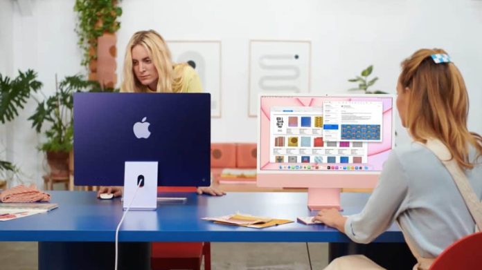 Duas mulheres usando modelos azul e rosa de iMac de 24 polegadas
