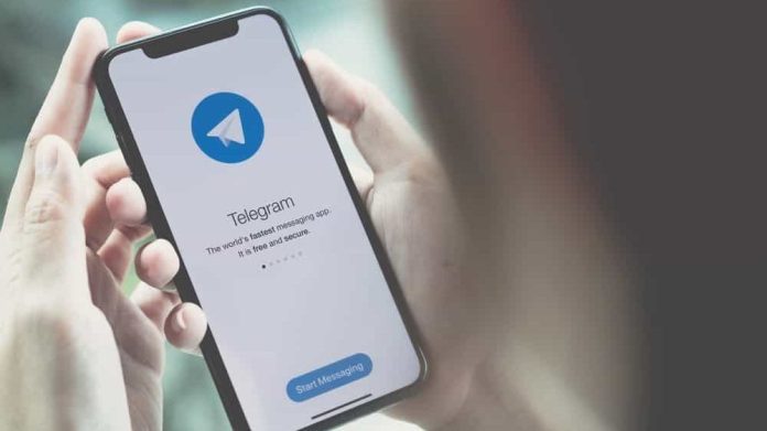 Pessoa segurando iPhone, no qual abre o Telegram pela primeira vez