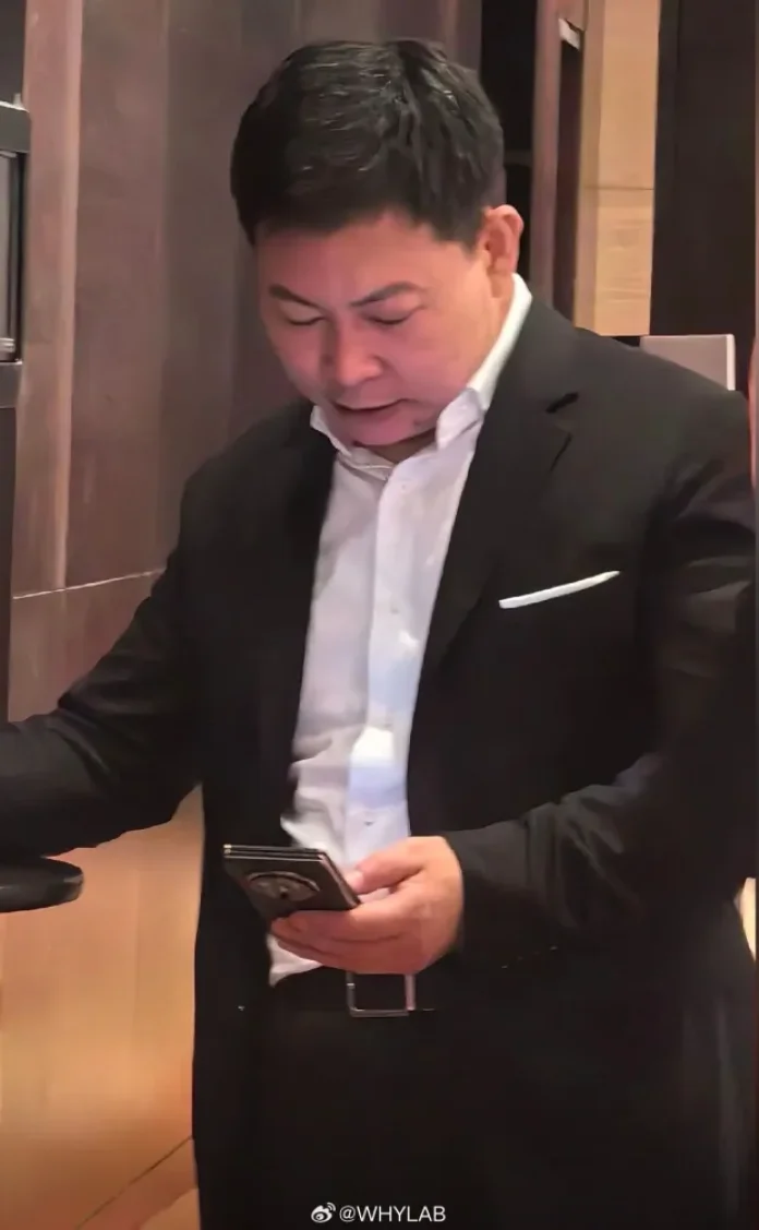 Richard Wu olhando para um celular