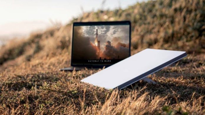 Starlink Mini, nova antena da empresa, ao lado de notebook no mato