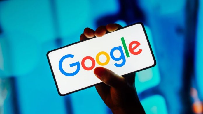 Mão segurando smartphone que está mostrando o logo do Google