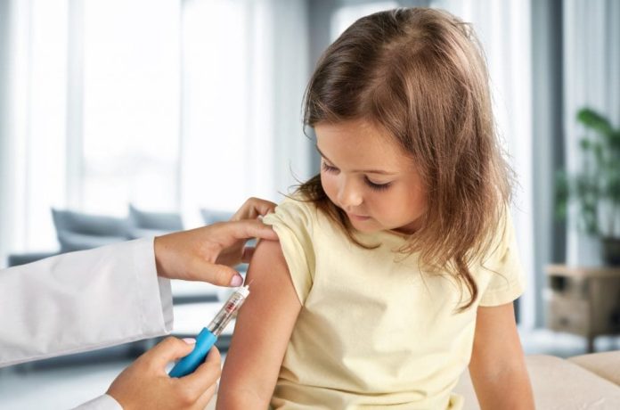 Médico pediatra aplicando vacina em criança