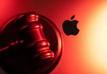 Martelo de juiz em cima de um MacBook, exibindo o logo da Apple ao lado