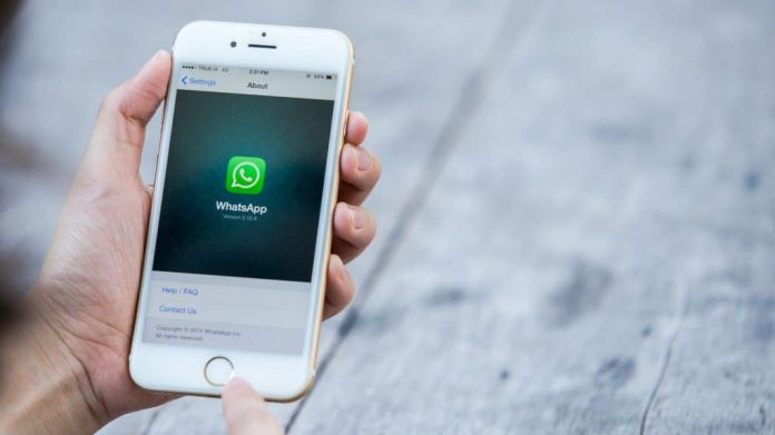 Pessoa acessando página sobre WhatsApp num iPhone 6