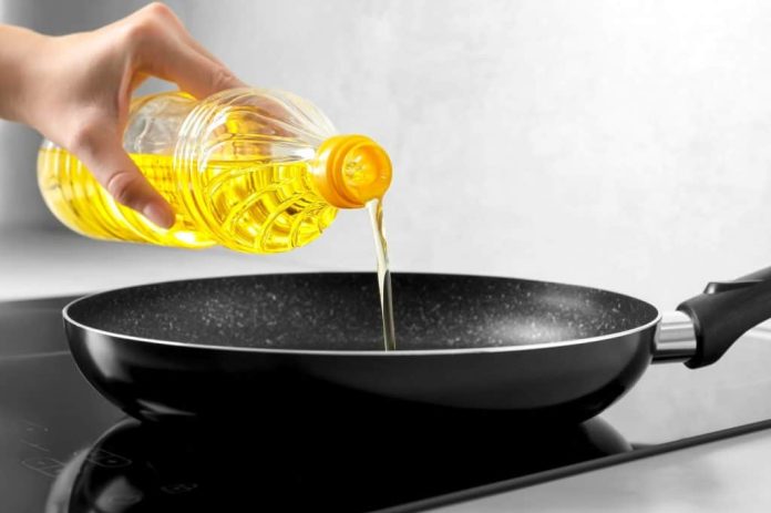 Óleo de cozinha sendo despejado em uma frigideira