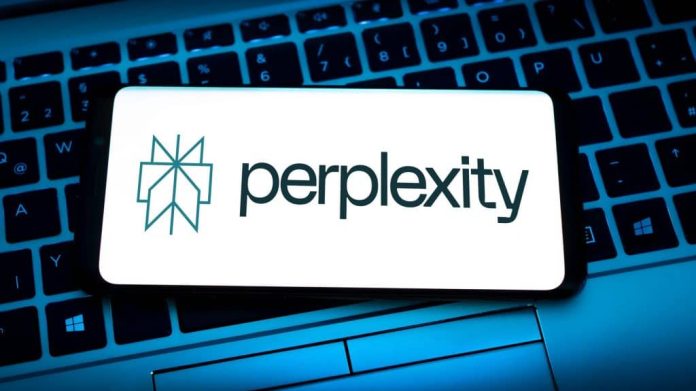 Celular com logotipo da Perplexity na tela em cima de teclado de notebook
