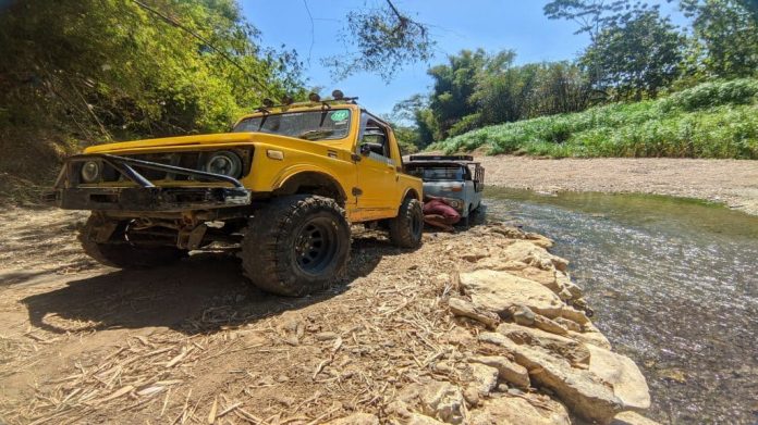 Jjipe ​​amarelo, modelo de carro com tração 4x4 puxa um caminhão que está preso na margem do rio Oya, Gunungkidul