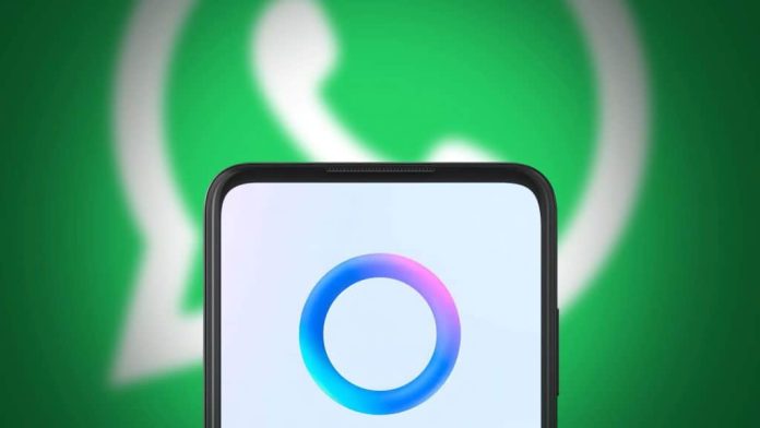 Celular com logomarca da Meta AI na frente de tela exibindo logomarca do WhatsApp