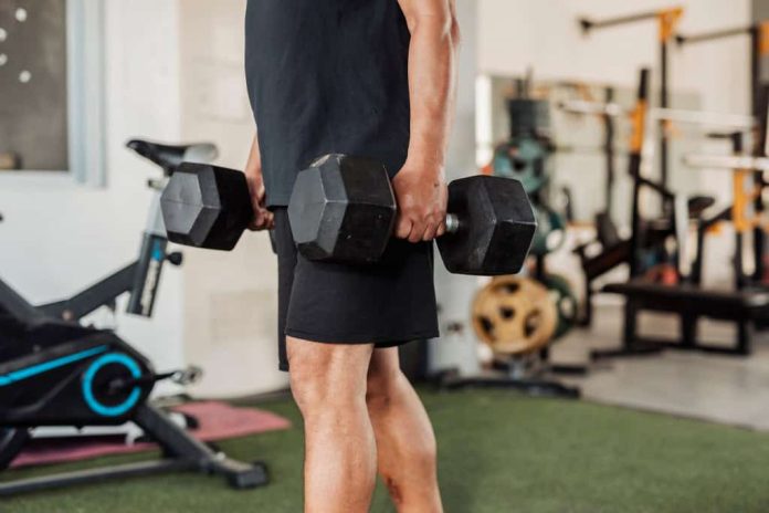 Homem com dois pesos nas mãos, um em cada uma