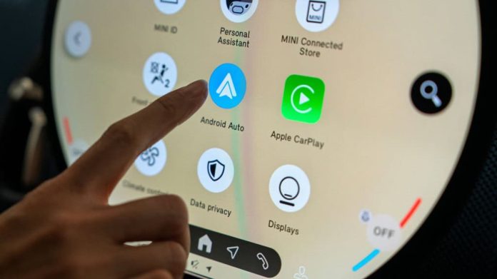 Penang, Malásia - 10 de maio de 2025: Vista em close-up do sistema de infoentretenimento com tela sensível ao toque no Novo MINI Countryman, com Android Auto e ícones do Apple CarPlay