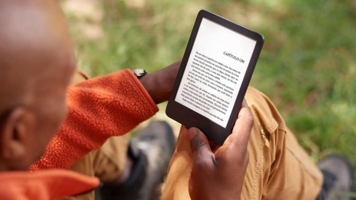 Homem lendo num Kindle num parque