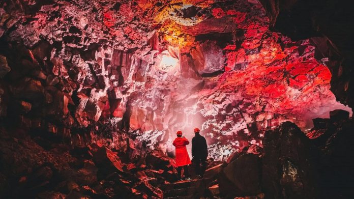 Dois turistas em túnel feito por lava na Terra