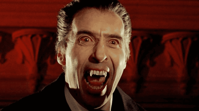 Christopher Lee como Drácula, vampiro com olhos arregalados, presas expostas e expressão agressiva, em referência ao tema “atores que mais morreram em filmes e séries”