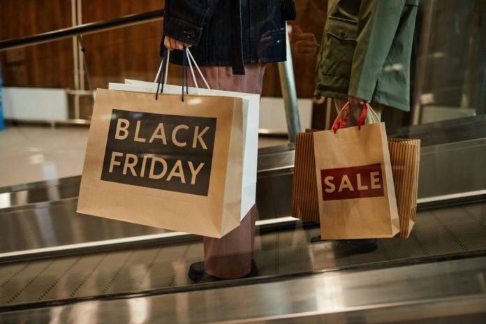 Pessoa segurando várias sacolas com a frase "Black Friday" impressa em cada uma