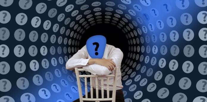 Montagem de pessoa rodeada por sinais de interrogação