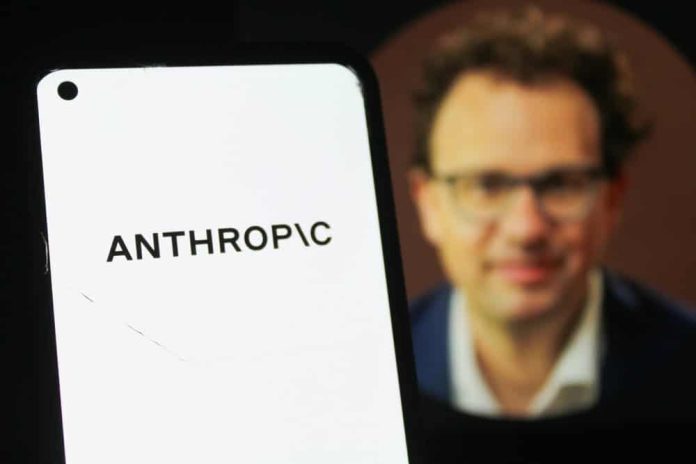 Anthropic vai à Justiça contra Pentágono, diz CEO Logo da Anthropic em primeiro plano em um smartphone; ao fundo, imagem desfocada de Dario Amodei